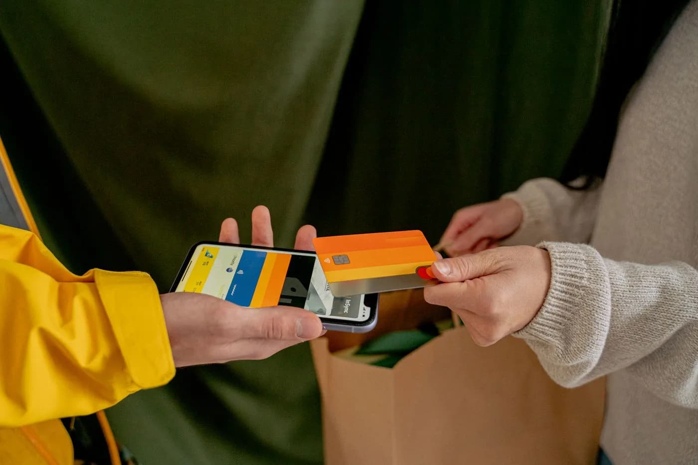 A customer tapping a card against a phone to pay